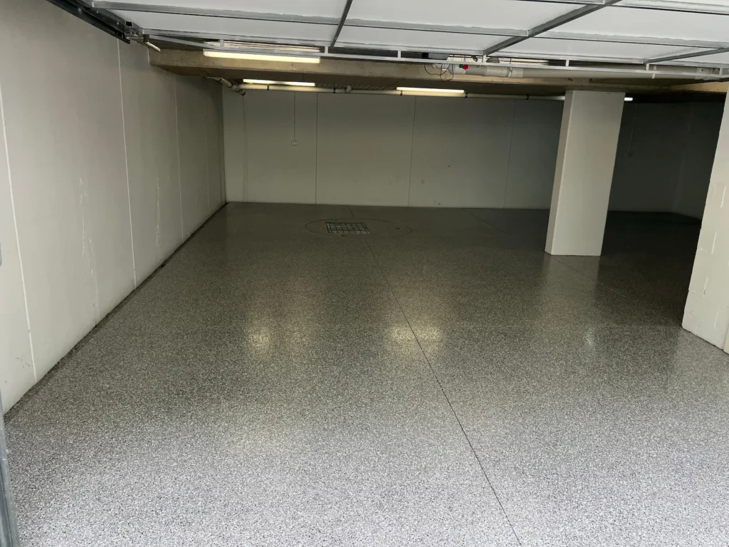 Light grey epoxy flake floor in a Delahey double car garage installed by Highend Epoxy Flooring