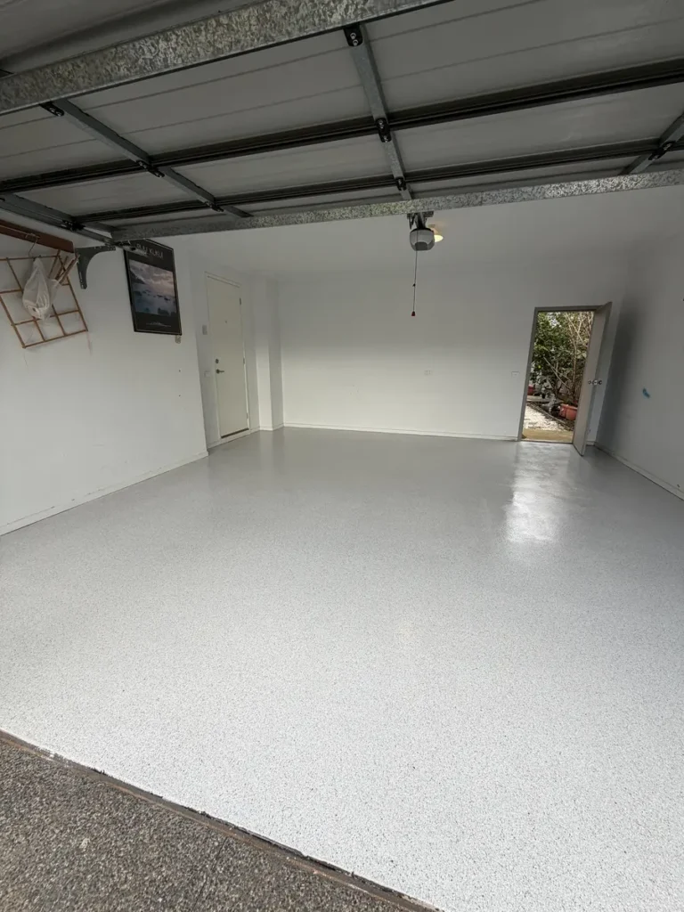 Warm grey non‑slip epoxy flake garage floor in Sydenham near a laundry door