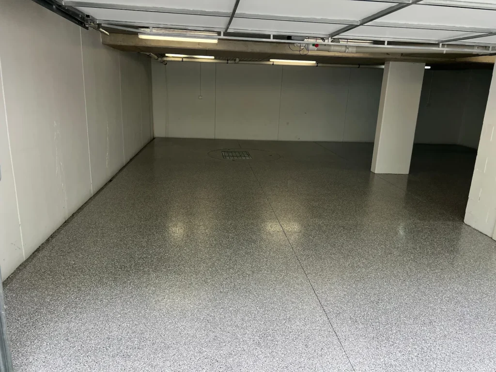 Light grey epoxy flake floor in a Delahey double car garage installed by Highend Epoxy Flooring